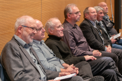 Die Künstler sitzen nebeneinander im großen Sitzungssaal