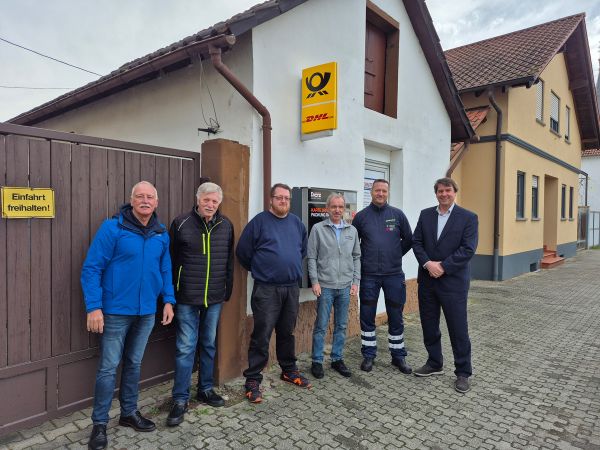 Vor der neuen Postfiliale in Huttenheim: Vertreter der Stadt und Betreiber freuen sich über den Neustart des Postservices im Ort.